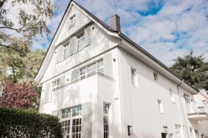 una casa blanca con ventanas y techo en Appartement salt mit Südterrasse, en Timmendorfer Strand