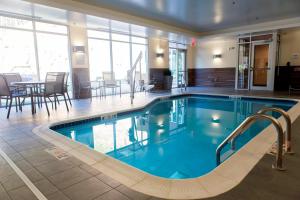 a large swimming pool in a hotel lobby with a table and chairs at Fairfield by Marriott Cambridge in Cambridge