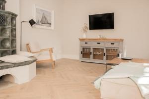 Una sala de estar con un televisor en una pared blanca. en Appartement salt mit Südterrasse, en Timmendorfer Strand