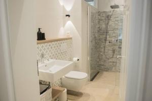 Un baño con inodoro, lavabo y ducha. en Appartement salt mit Südterrasse, en Timmendorfer Strand 32 fotos más