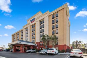 un hotel con coches estacionados en un estacionamiento en Fairfield Inn & Suites Anaheim North Buena Park, en Buena Park