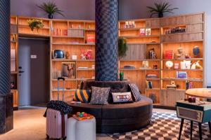 - un salon avec un canapé et une étagère à livres dans l'établissement Moxy The Hague, à La Haye