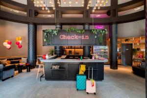 eine Lobby mit einem Check-in-Schalter mit Gepäck in der Unterkunft Moxy The Hague in Den Haag