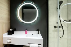 a bathroom with a white sink and a mirror at Moxy The Hague in The Hague +18 photos