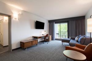 a living room with a couch and a desk at Courtyard Orlando Altamonte Springs Maitland in Orlando