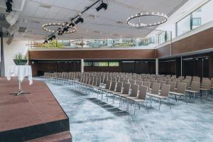 Großes Zimmer mit Stühlen, Tischen und Lichtern in der Unterkunft Courtyard by Marriott Stockholm Kungsholmen in Stockholm