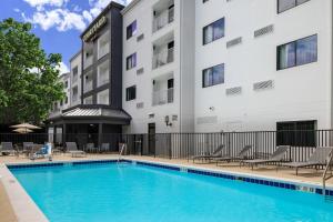 a swimming pool in front of a hotel with chairs and a building at Courtyard Orlando Altamonte Springs Maitland in Orlando