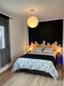 1 dormitorio con 1 cama grande y cabecero negro en Maison de village, en Mormoiron