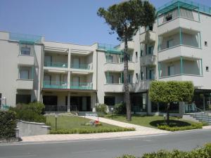 un edificio de apartamentos al lado de una calle en Hotel Flora, en Marina di Bibbona