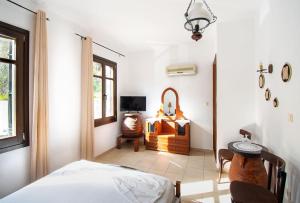 1 dormitorio con cama, silla y escritorio en Pali Sea View, en Páloi