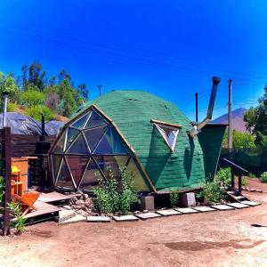 a large green dome house sitting in a yard at Lodge Liquitay in Hijuelas