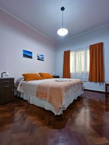 een slaapkamer met een groot bed met oranje kussens bij El Oasis in Mendoza