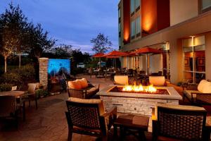 une terrasse avec un foyer extérieur, des chaises et des tables dans l'établissement SpringHill Suites by Marriott Pittsburgh Latrobe, à Latrobe