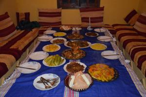 a long blue table with plates of food on it at Auberge Casa Linda in Chefchaouen