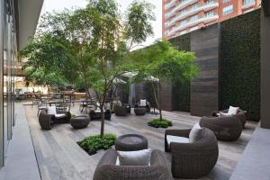 un patio con sofás, mesas y árboles en Courtyard by Marriott Guatemala City, en Guatemala