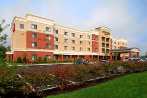 a hotel building with cars parked in a parking lot at Courtyard Pittsburgh Greensburg in Greensburg