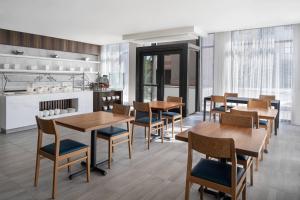 uma sala de jantar com mesas e cadeiras de madeira em AC Hotel by Marriott Santa Rosa Sonoma Wine Country em Santa Rosa