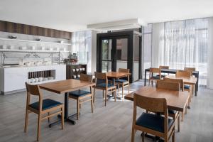 a dining room with wooden tables and chairs at AC Hotel by Marriott Santa Rosa Sonoma Wine Country in Santa Rosa