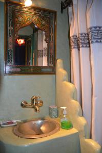a bathroom with a sink with a mirror and a sink at Auberge Casa Linda in Chefchaouen