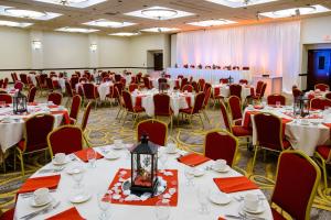 ロチェスターにあるRochester Marriott Mayo Clinic Areaのテーブルと椅子と赤いナプキンを用意した宴会場