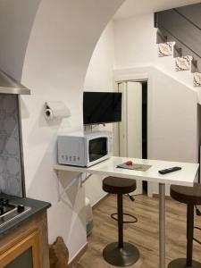 cocina con escritorio, microondas y taburete en INTERNATIONAL GARIBALDI *, en Nápoles