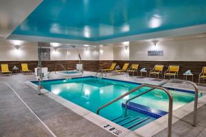 a large pool in a hotel room with yellow chairs at Fairfield Inn & Suites by Marriott Alexandria,Virginia in Alexandria