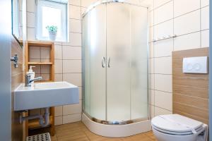 a bathroom with a shower and a toilet and a sink at Pensjonat Nautilus in Karwia +35 photos