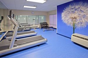 a room with a gym with treadmills and a large flower at SpringHill Suites Louisville Hurstbourne/North in Louisville