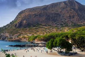 a group of people on a beach with a mountain at Casa de Férias in Tarrafal