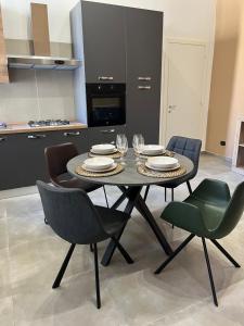 een eettafel met stoelen en borden en wijnglazen bij Palazzo Ferrara Apartment in Napels