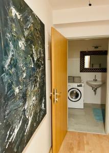 a door to a bathroom with a sink and a washing machine at Cozy & Charming City Apartment in Vienna