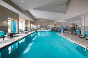 una piscina en una habitación de hotel con sillas azules en Residence Inn by Marriott Texarkana, en Texarkana