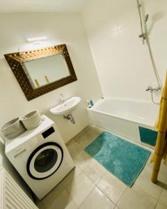 La salle de bains est pourvue d'un lave-linge et d'une baignoire. dans l'établissement Cozy & Charming City Apartment, à Vienne