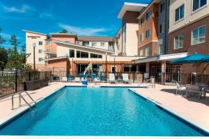 einen Pool in einem Hotel mit Tischen und Stühlen in der Unterkunft Residence Inn by Marriott Houston City Place in Spring