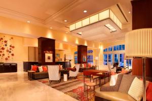 Habitación grande con vestíbulo con sofás y sillas. en Houston Marriott Sugar Land en Sugar Land