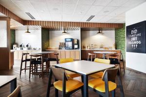un restaurante con mesas y sillas y una cocina en Fairfield Inn & Suites Sheboygan, en Sheboygan