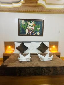 a bedroom with a large bed with three white pillows at Villa Marii in Dipolog