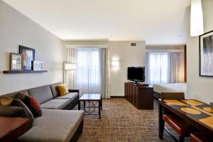 une chambre d'hôtel avec un canapé, un lit et une télévision dans l'établissement Residence Inn Saint Louis O'Fallon, à O'Fallon