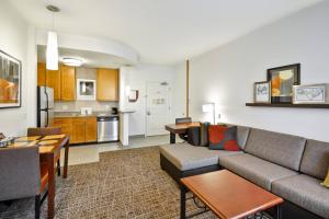 a living room with a couch and a kitchen at Residence Inn Saint Louis O'Fallon in O'Fallon