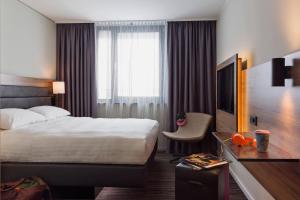 a hotel room with a bed and a television at Moxy Stuttgart Airport/Messe in Leinfelden-Echterdingen