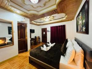 a bedroom with a large black bed with white pillows at Villa Marii in Dipolog