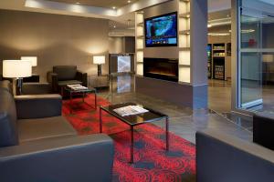 a lobby with couches and a table and a television at Residence Inn by Marriott Montréal Downtown in Montreal