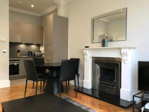 uma sala de estar com uma mesa e uma lareira em 25 Ongar Road by Viridian Apartments em Londres