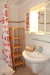 ein Bad mit einem Waschbecken und einem Spiegel in der Unterkunft Unter den Linden - 3 in Dahme