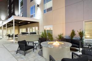 - une terrasse avec un foyer extérieur dans un bâtiment dans l'établissement TownePlace Suites by Marriott Tampa Casino Area, à Tampa