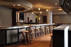 un bar con una fila de taburetes en un restaurante en Spring Hill Suites Minneapolis-St. Paul Airport/Mall Of America en Bloomington