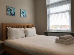 um quarto com uma cama com toalhas em 25 Ongar Road by Viridian Apartments em Londres