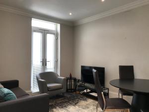 a living room with a couch and a table and a television at 25 Ongar Road by Viridian Apartments in London