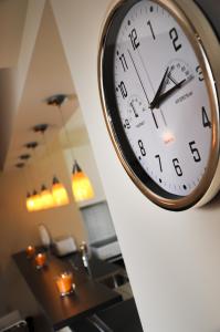 un reloj colgando de una pared en una habitación en DERELLI Elegance Apartment, en Sofía