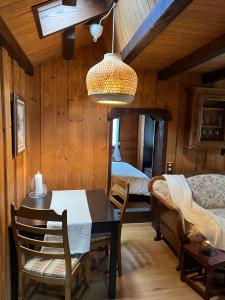 ein Esszimmer mit einem Tisch und ein Schlafzimmer in der Unterkunft Entire cozy chalet in St-Cergue - 30 min from Geneva in Saint-Cergue